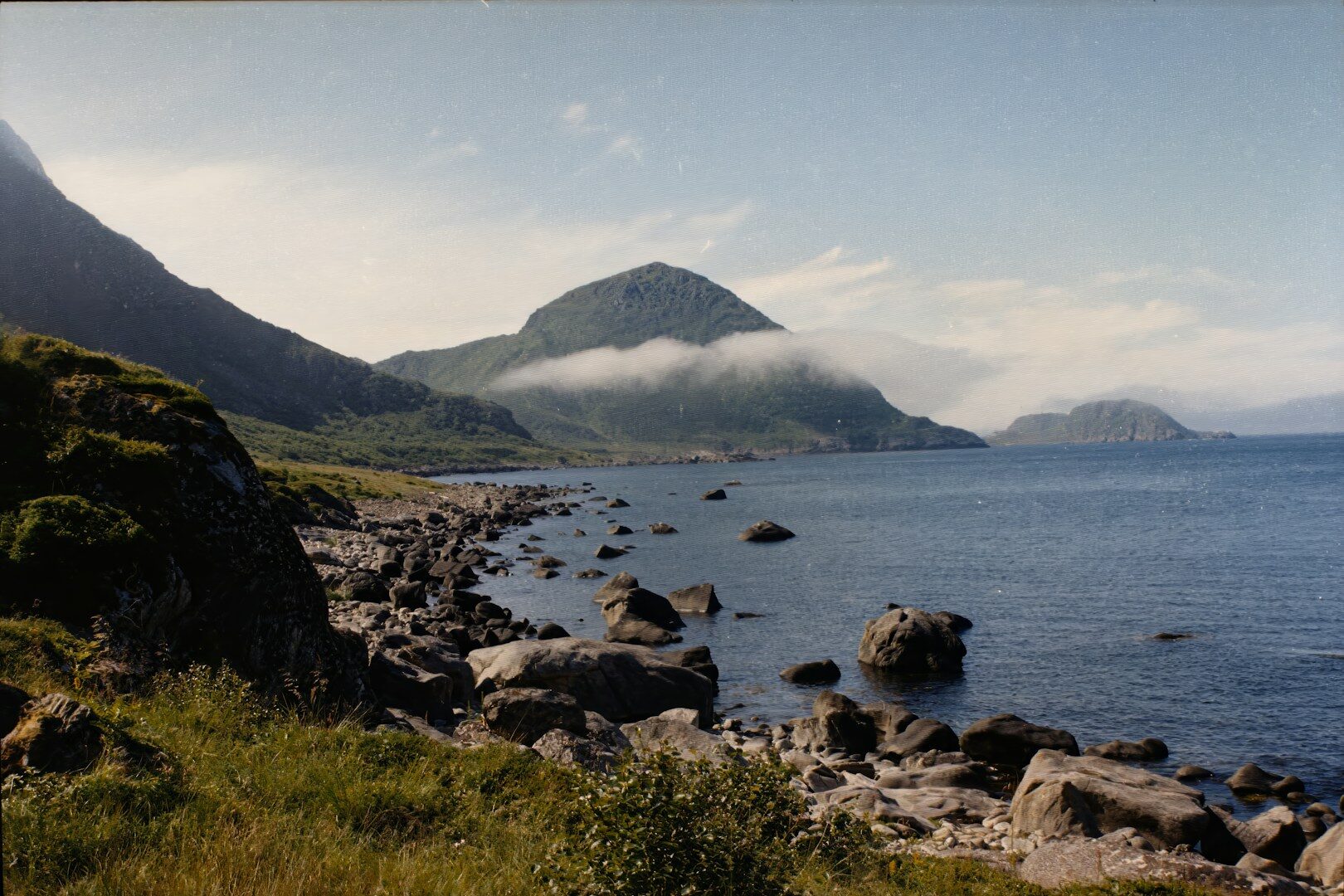 A body of water with mountains in the background